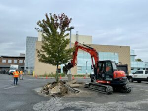 An orange excavator digs in the parking lot at Kemptville District Hospital. 