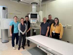 Hospital staff stand around the new x-ray machine that is operational